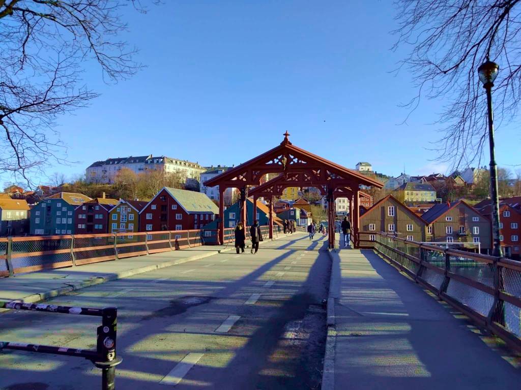 Trondheim old bridge and old town. A red wooden arch bridge with colorful houses and a blue sky
