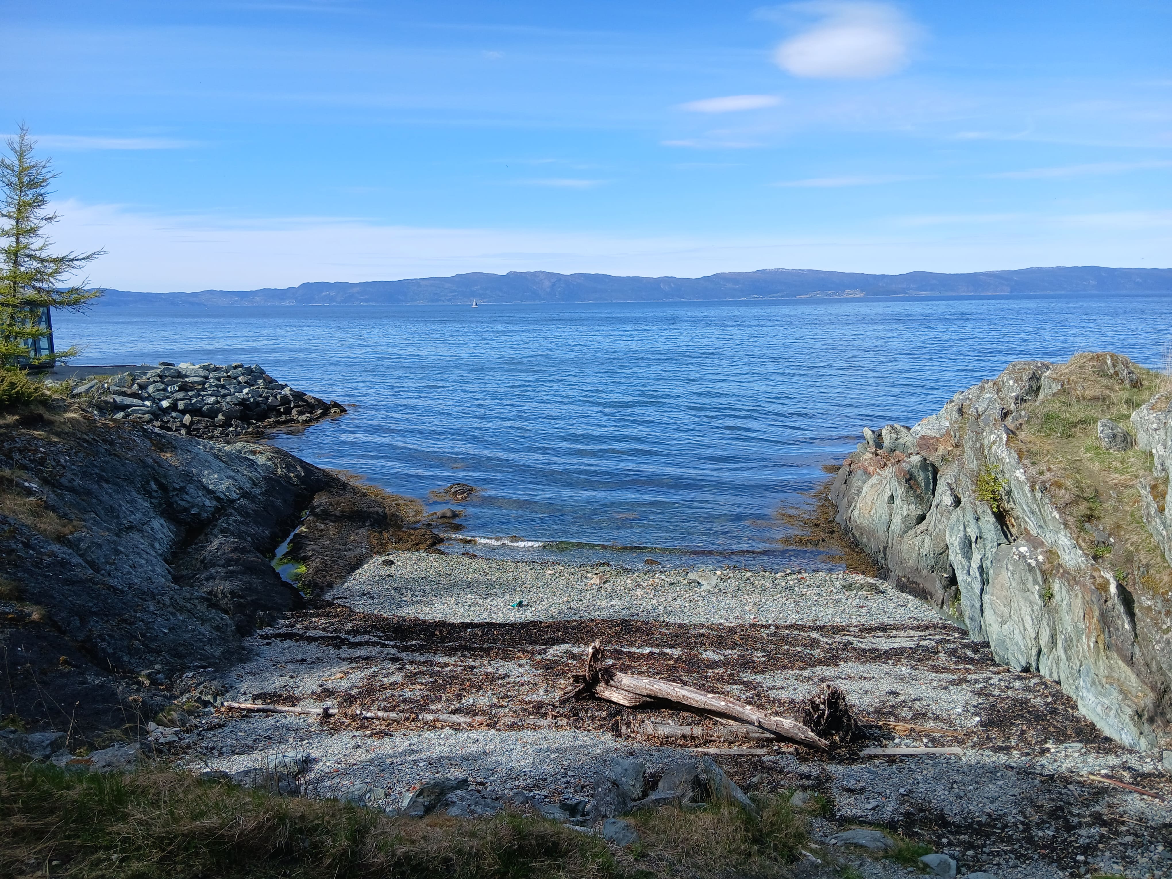 sea shore with a beach and large rocks along the Trondheim's fjord